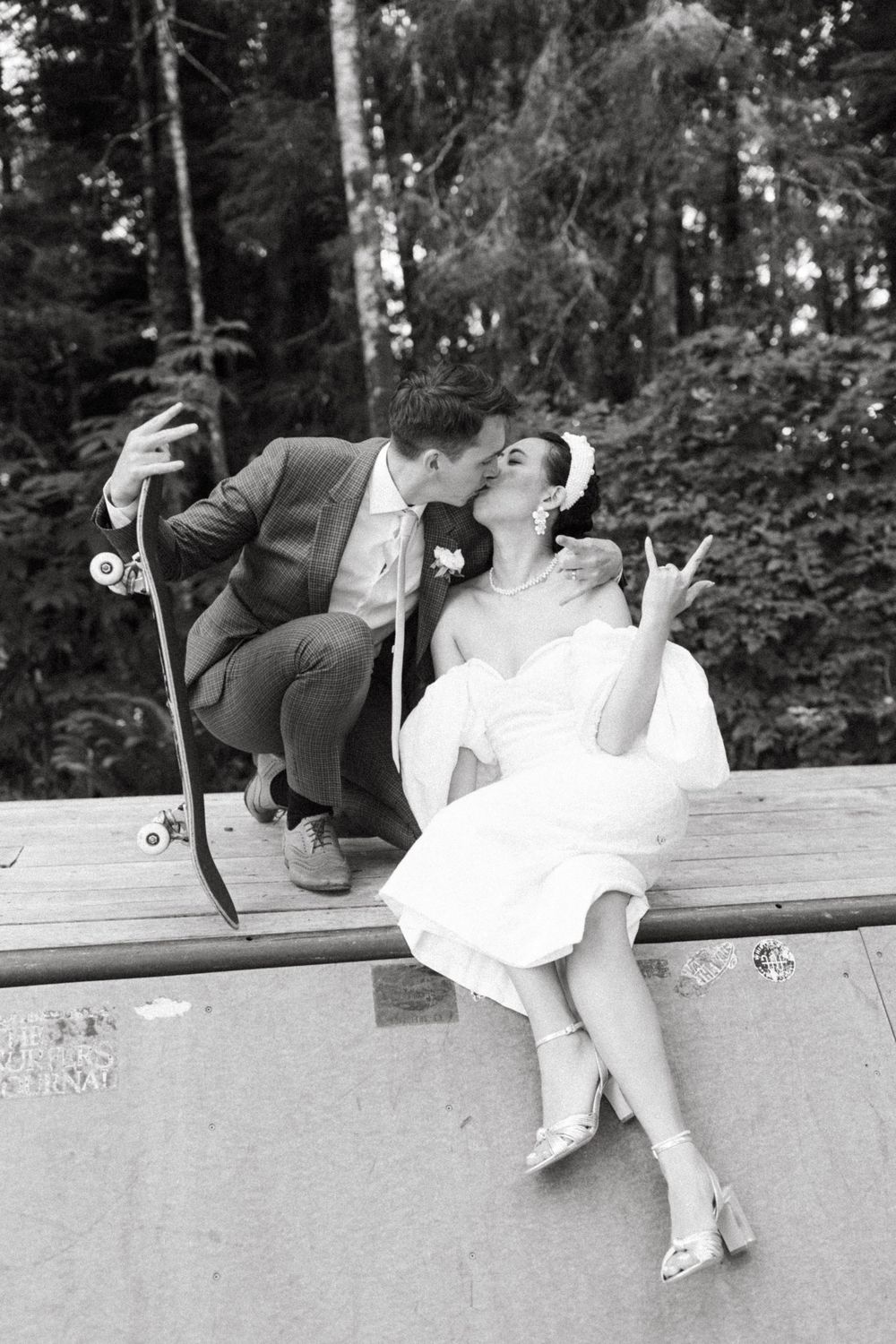 Playful black and white sequence of a couple sitting on a ledge.