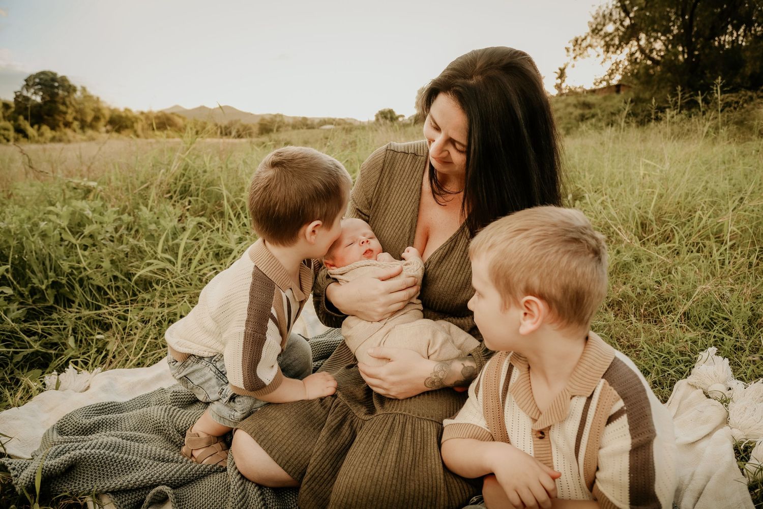 Mum and children sitting outside in the sunset