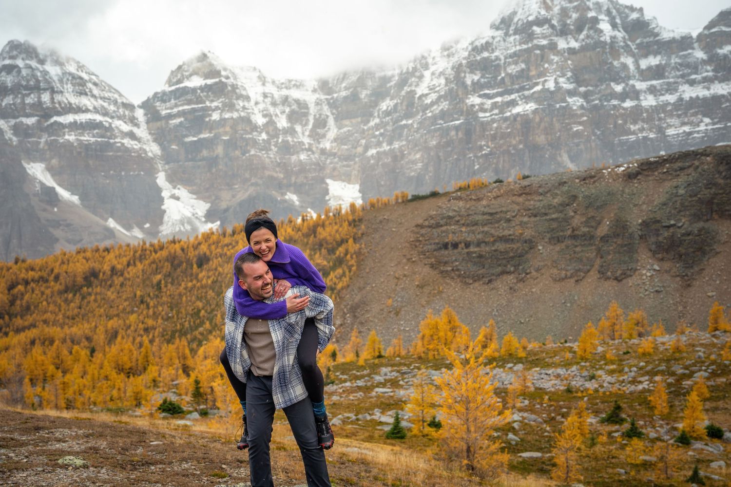 Scenic mountain landscape with colorful autumn larches and snow-capped peaks in the background.