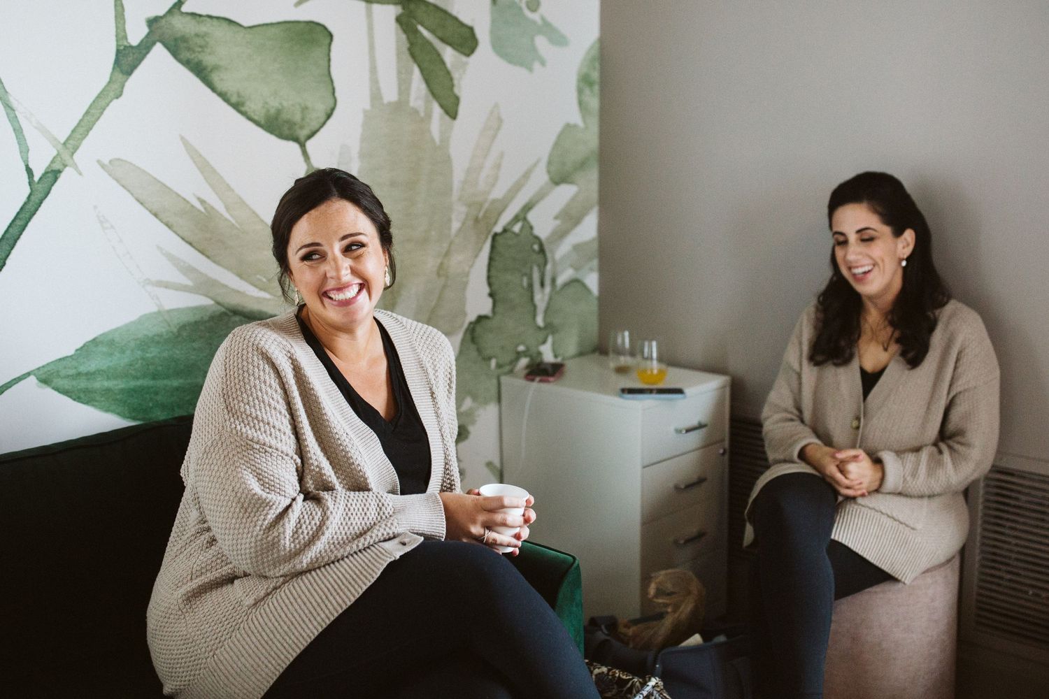 Casual indoor gathering with natural lighting and cozy sweater attire.