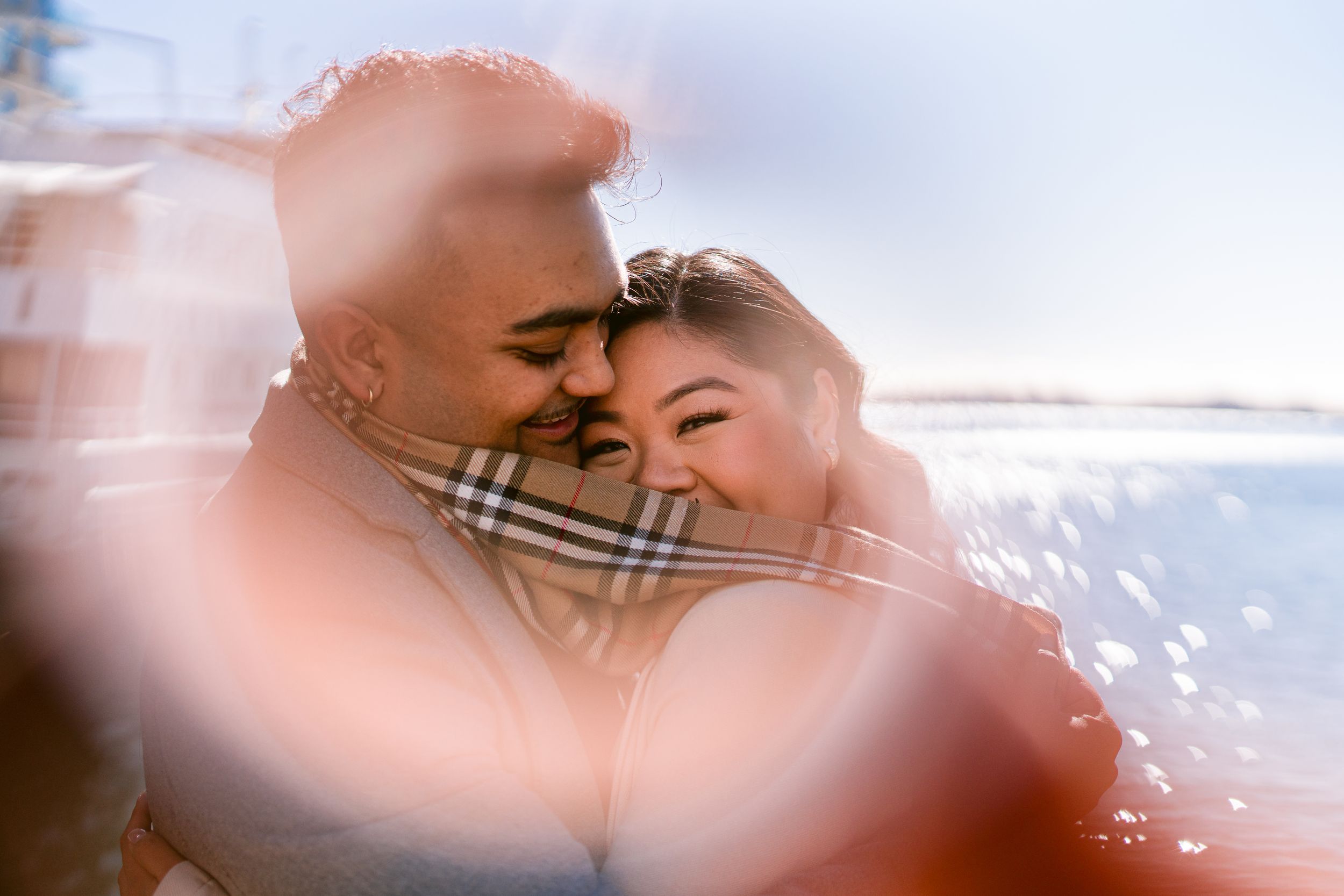 Intimate couple shares a romantic moment outdoors with a dreamy soft focus lens effect.