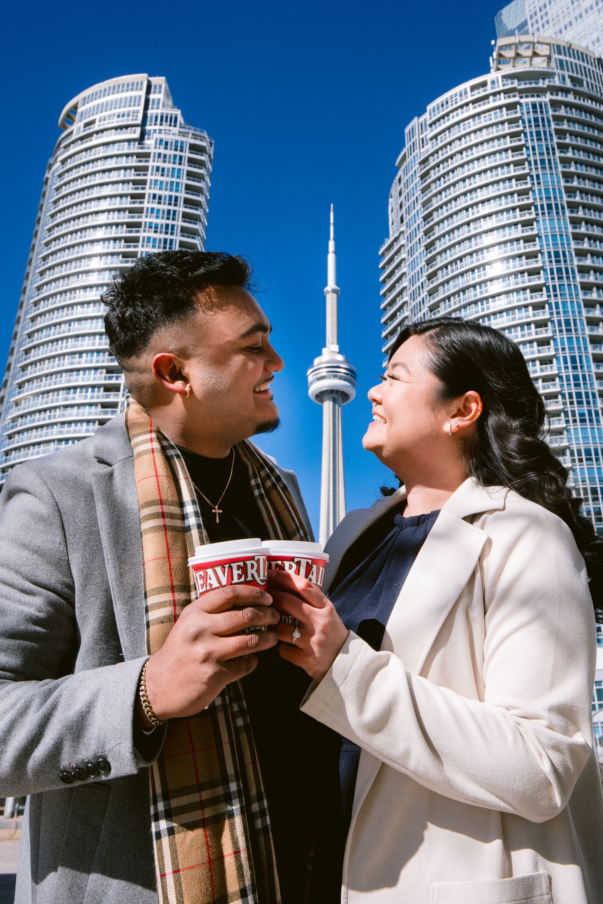 Urban scene in Toronto with CN Tower and modern glass condos as two people share a beverage.