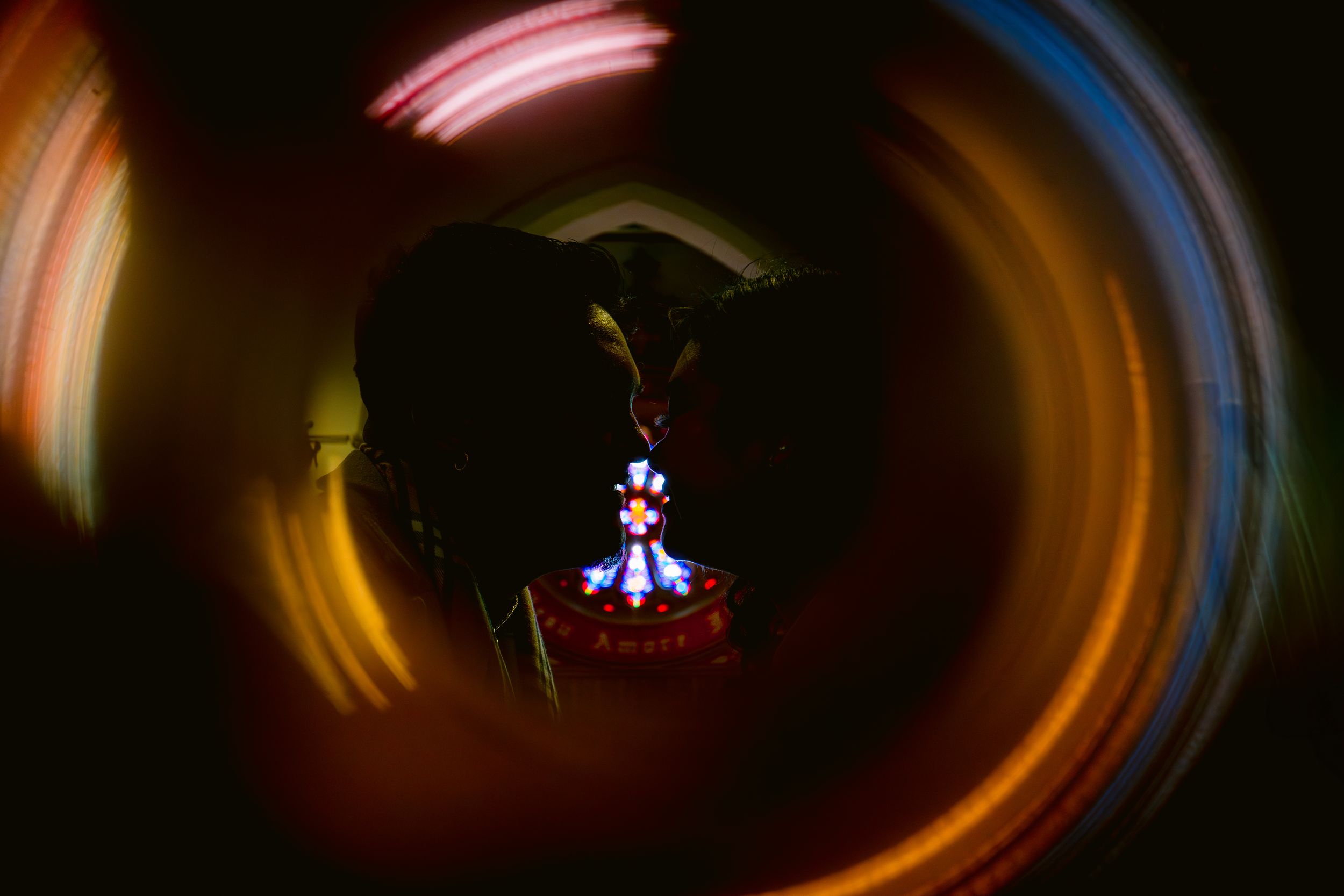 Abstract long exposure photo with circular light trails creating a swirling motion effect around a dark silhouette.