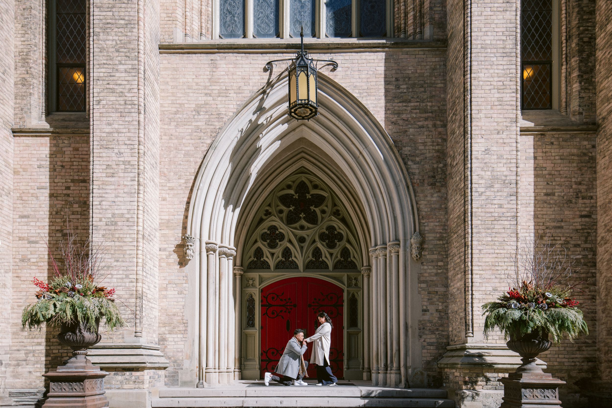 Gothic church archway decorated with hanging planters and ornate architectural details.