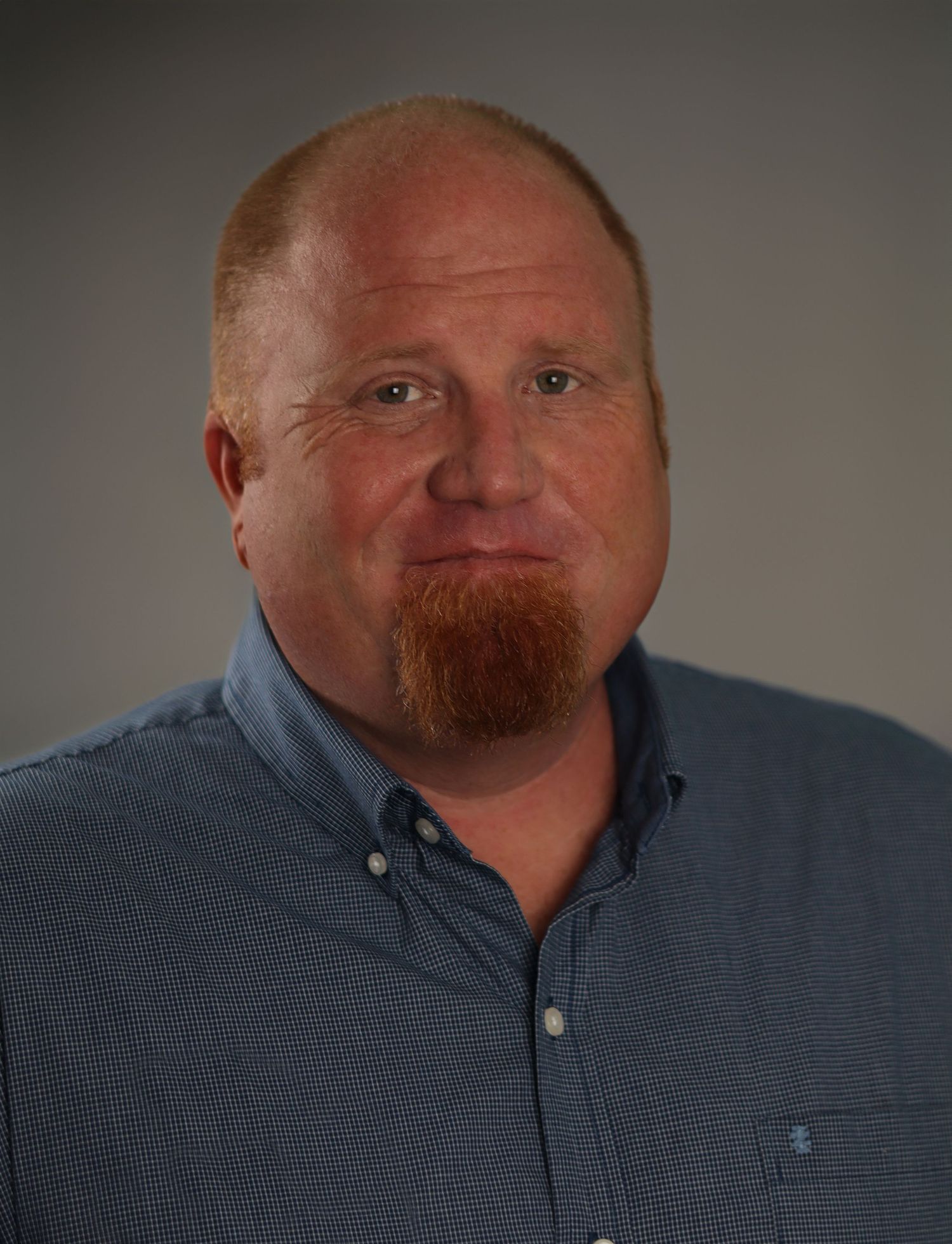 Joe, a middle aged male with red hair smiles as photographer Heather Hathaway captures his essence.