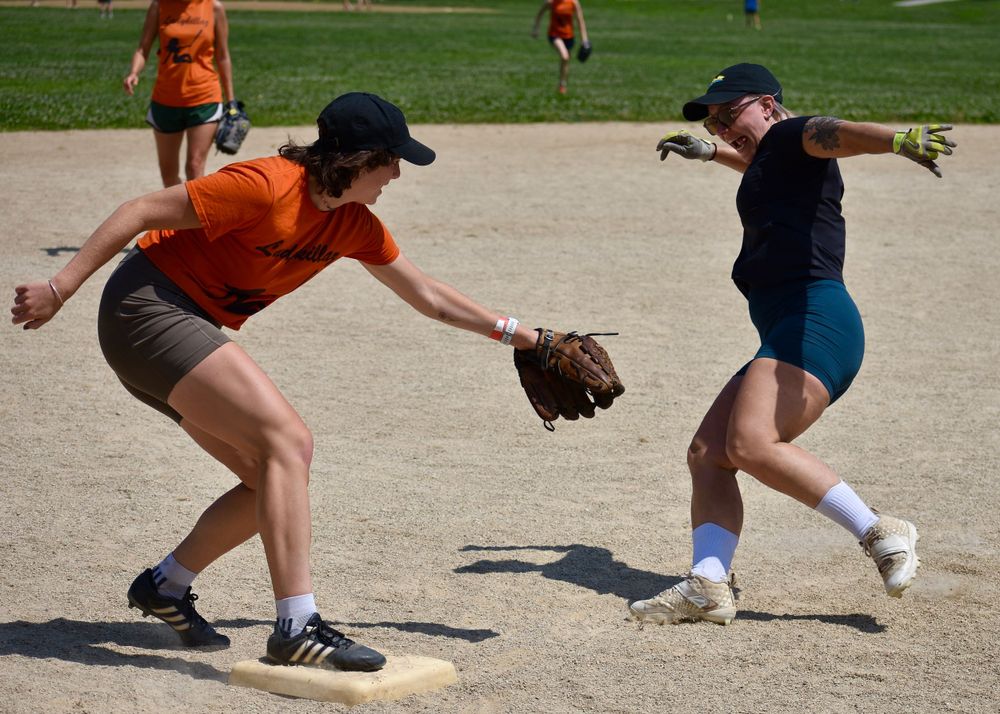 A CMSA softball player slides into third base attempting to dodge a tag at the Lincoln Park Waveland Softball Fields in Chicago