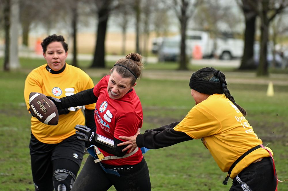 One CMSA flag football player reaches for the ball carrier's flags in a game at Cricket Hill in Chicago