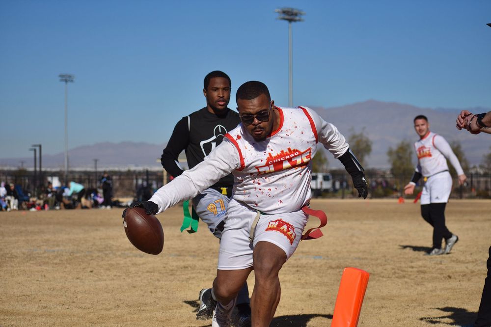 A flag football player from Chicago reaches the football across the endzone marker to score a touchdown