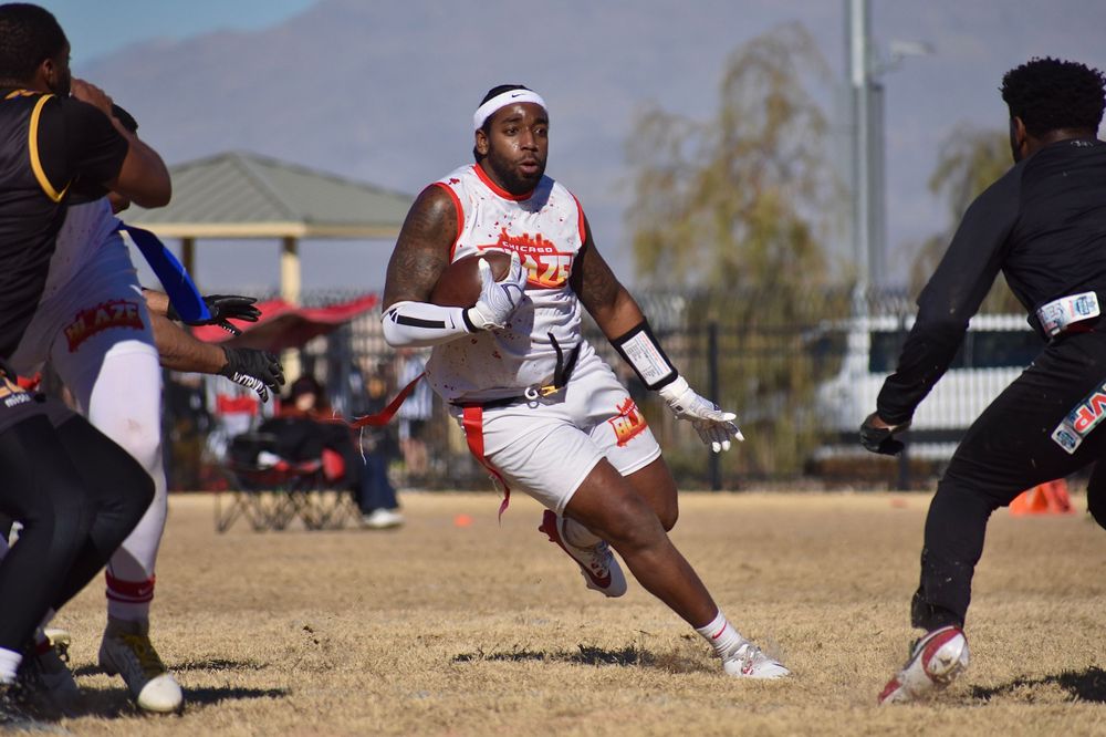 A flag football player from Chicago attempts to find the gap through opponents in order to move the football downfield