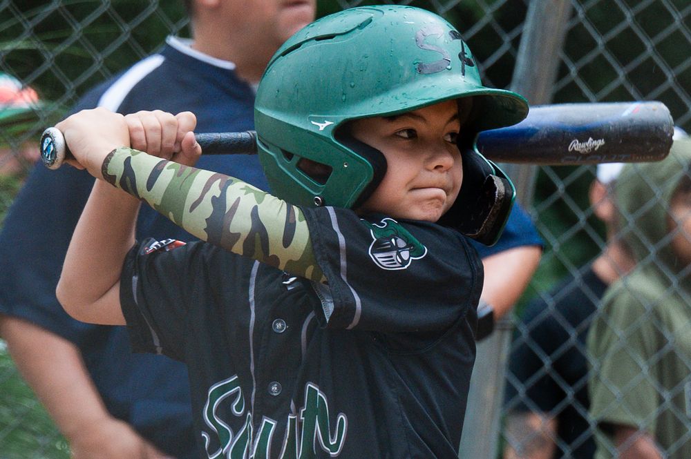 Youth baseball players practicing batting stance with bats during training session.