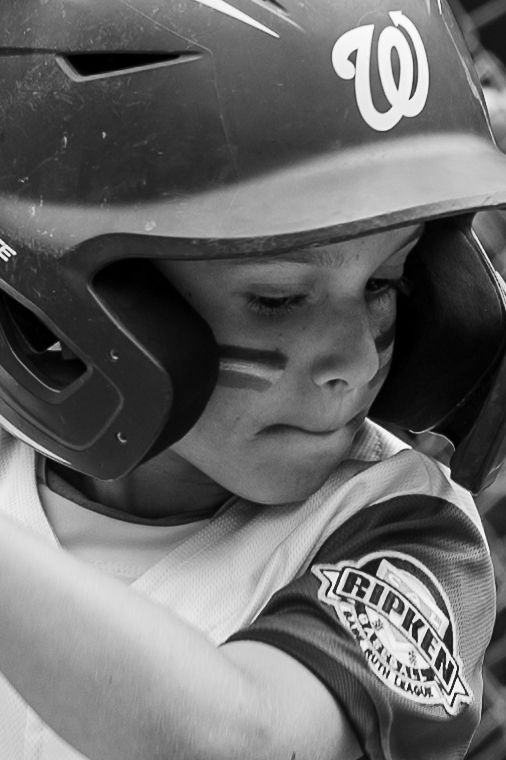 Baseball player wearing protective batting helmet during game shown in black and white.