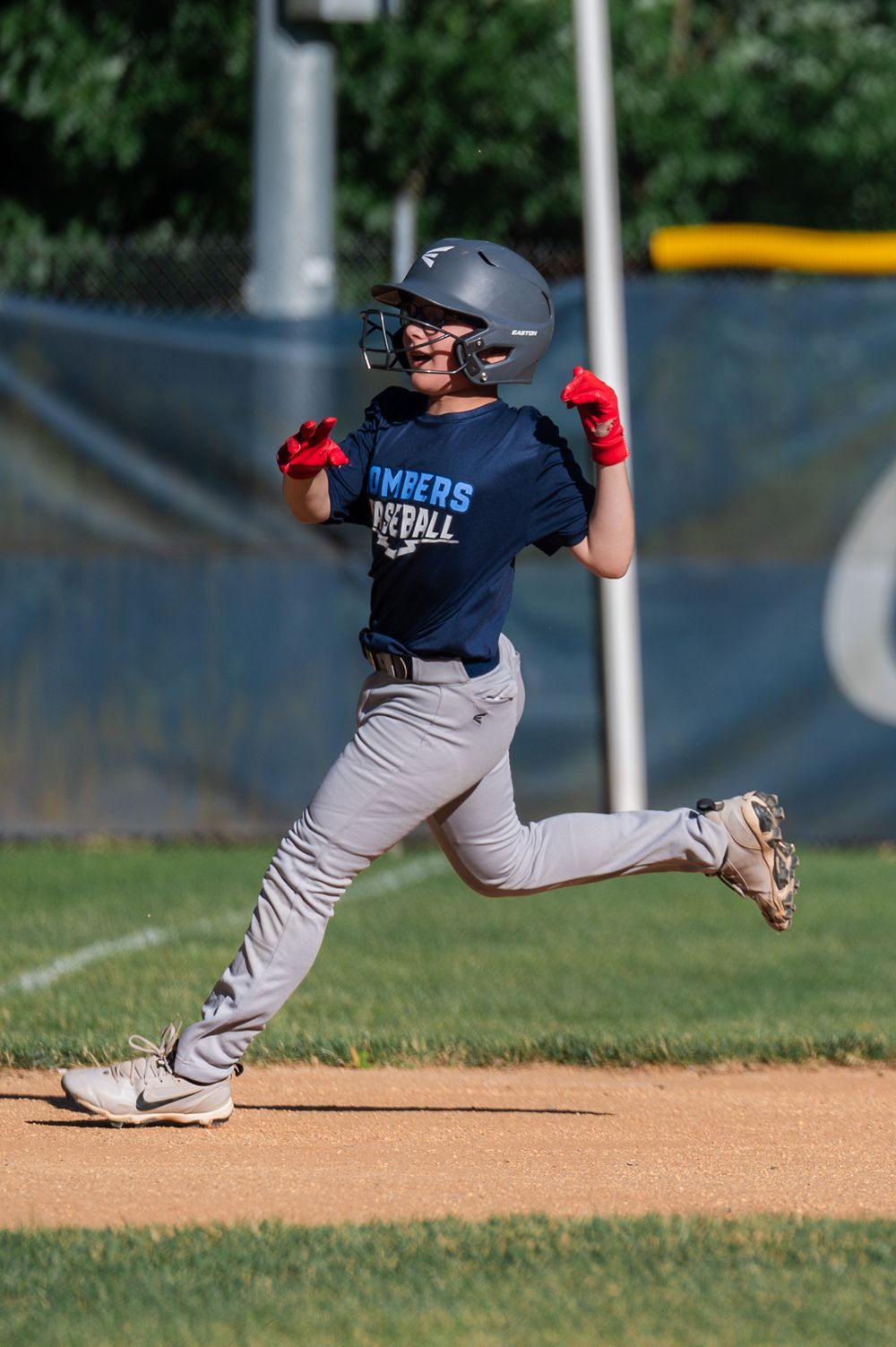 Baseball player in uniform slides into base during competitive game action.