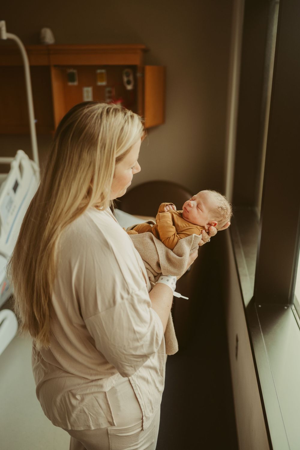 Mom holds newborn baby boy born at Blanchfield Army Community Hospital in Fort Campbell, Kentucky documented by Disney Magic Photography.