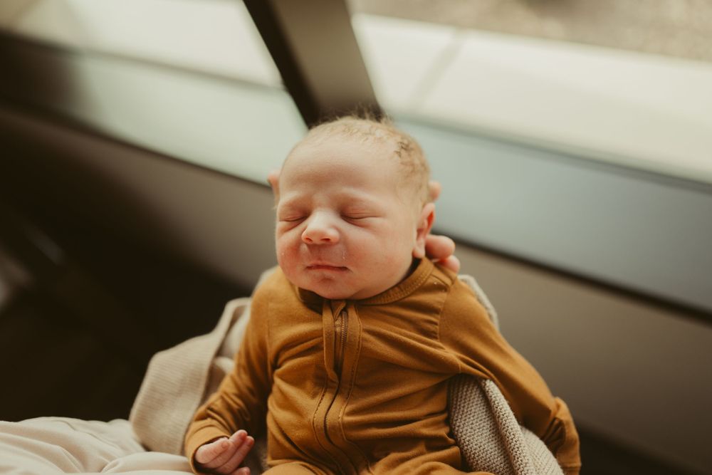 Baby boy in rust bamboo sleeper photographed on Fort Campbell Kentucky by Disney Magic Photography, local newborn photographer