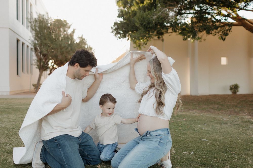 A heartwarming family photo session with a white sheet backdrop outdoors.