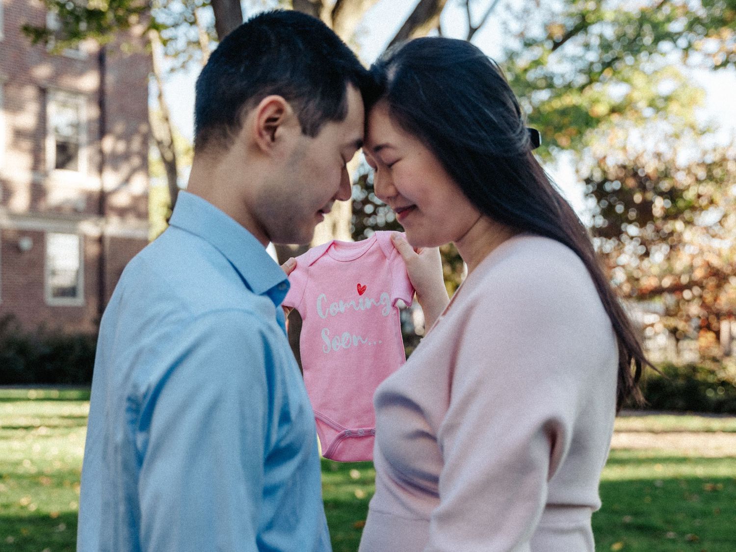 A couple shares an intimate moment while holding a pink plush toy between them at Harvard campus.