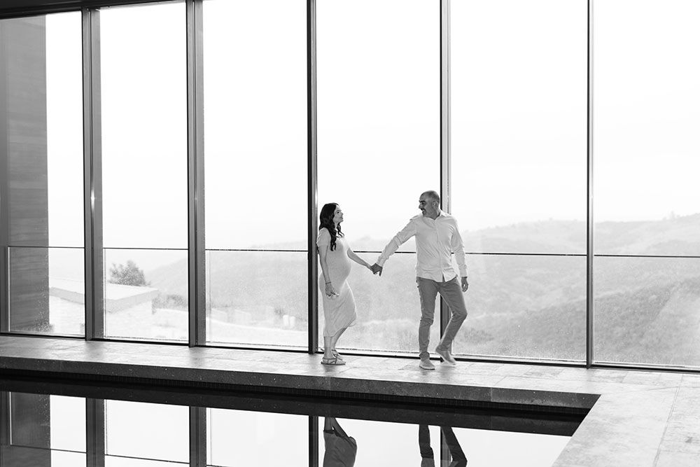 Elegant black and white maternity photo of a couple holding hands at Minthis Hills, Cyprus, by George Avgousti Photography.