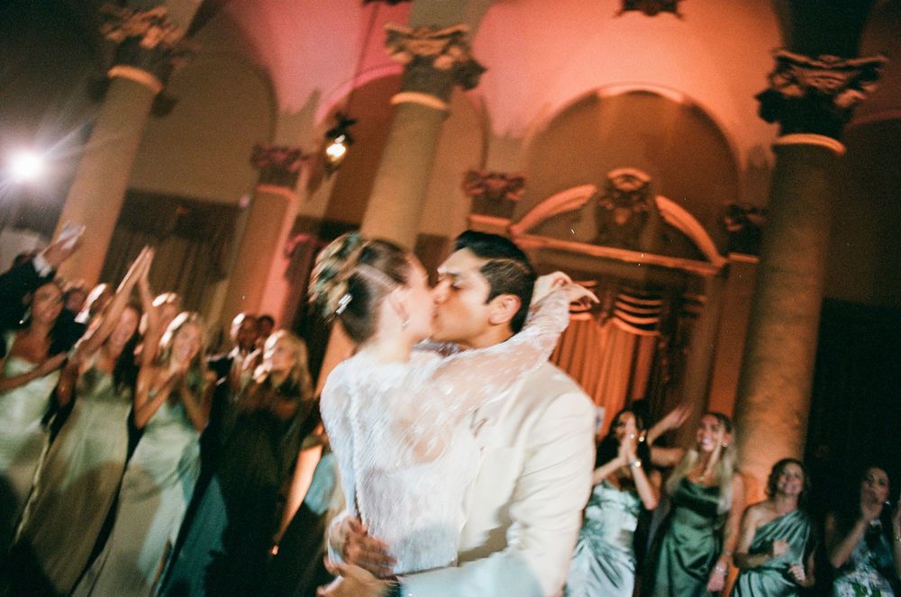 Couples dancing together at an elegant indoor wedding reception with warm ambient lighting.