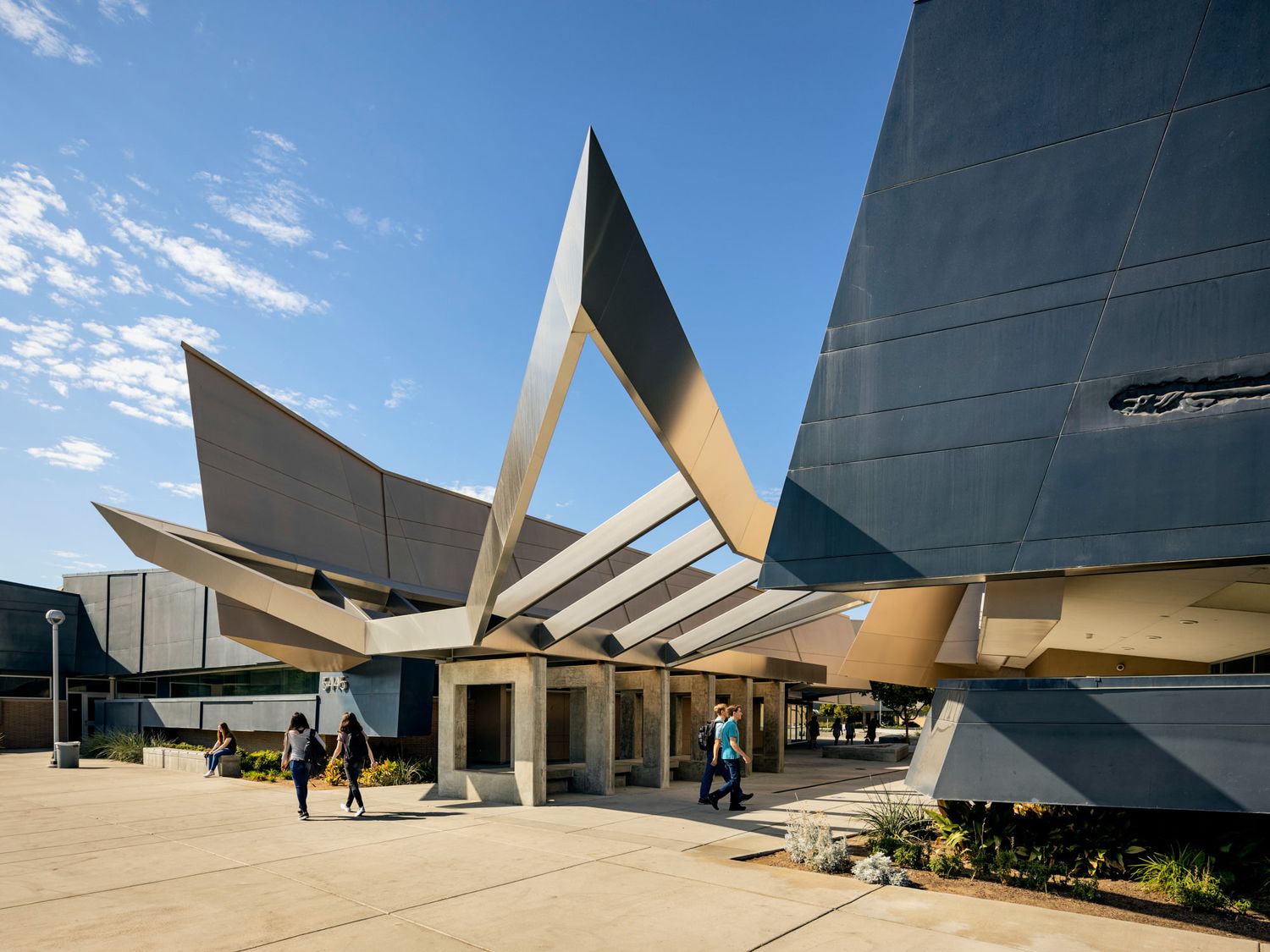 Modern angular architecture with dramatic geometric shapes and glass panels creates a striking contemporary building exterior.
