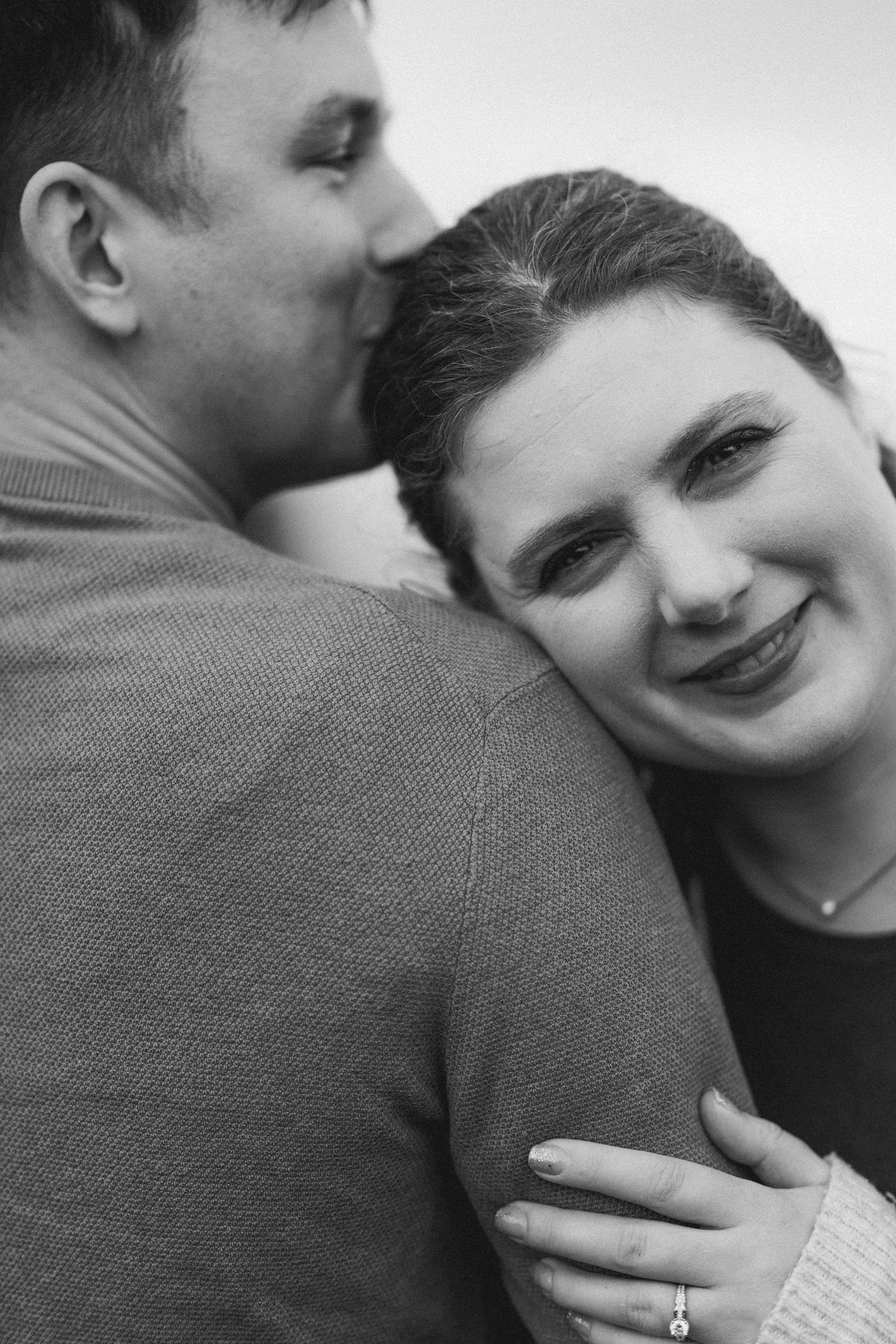 Black and white intimate portrait series showing tender embrace between two people in grayscale tones.