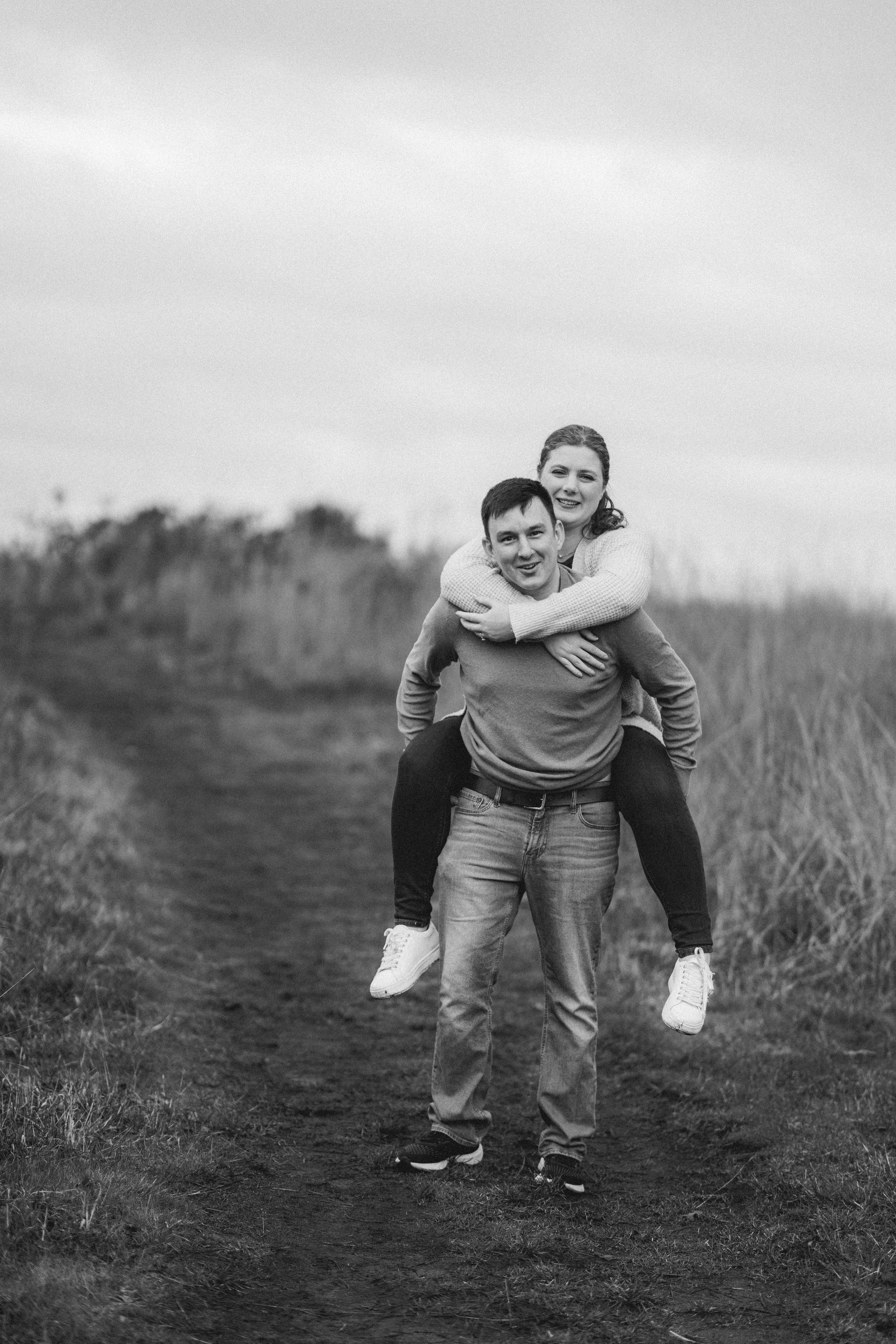 Playful black and white photo sequence of a piggyback ride in an outdoor field.