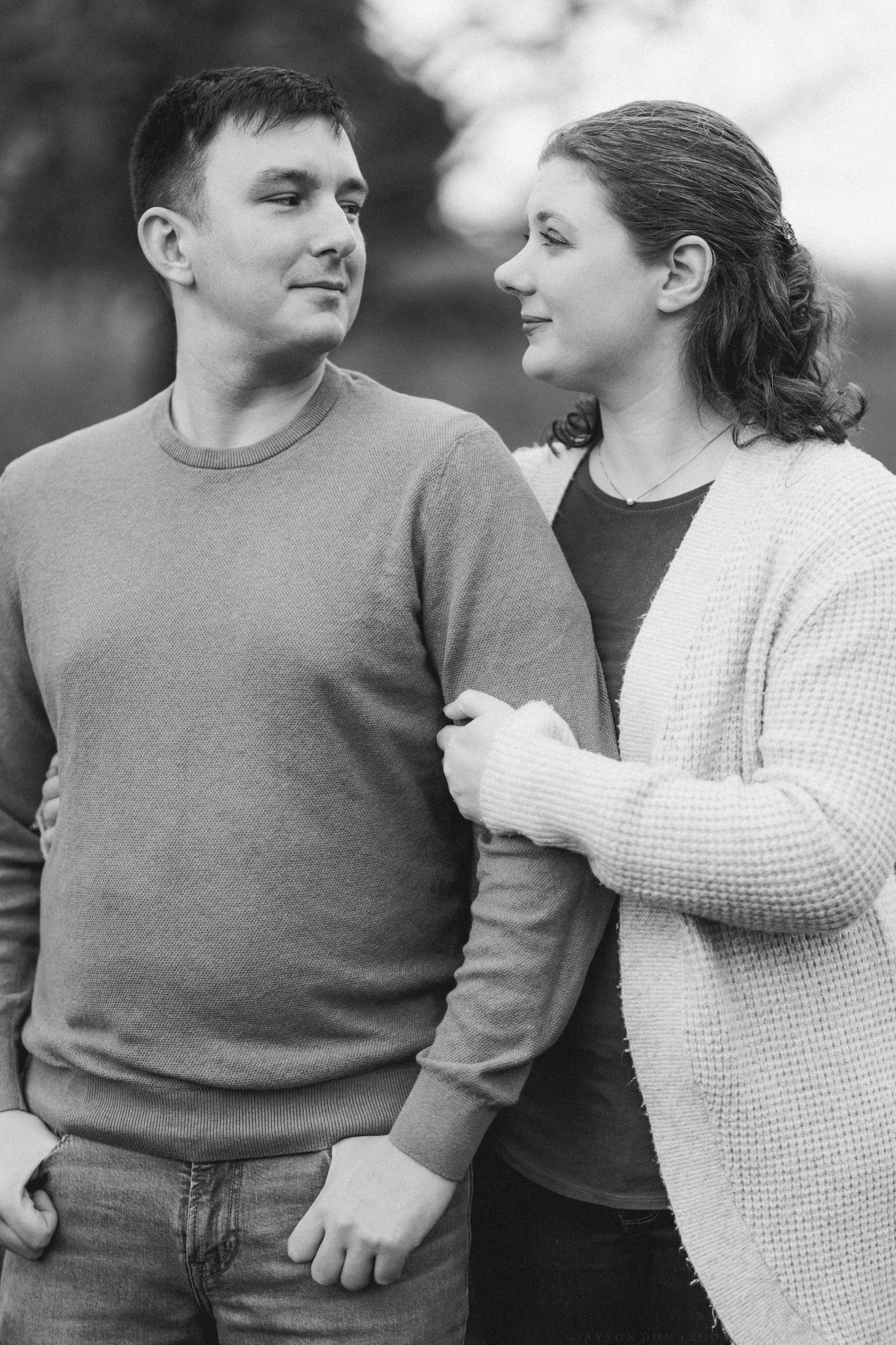 A couple in casual sweaters share an intimate moment together in black and white.