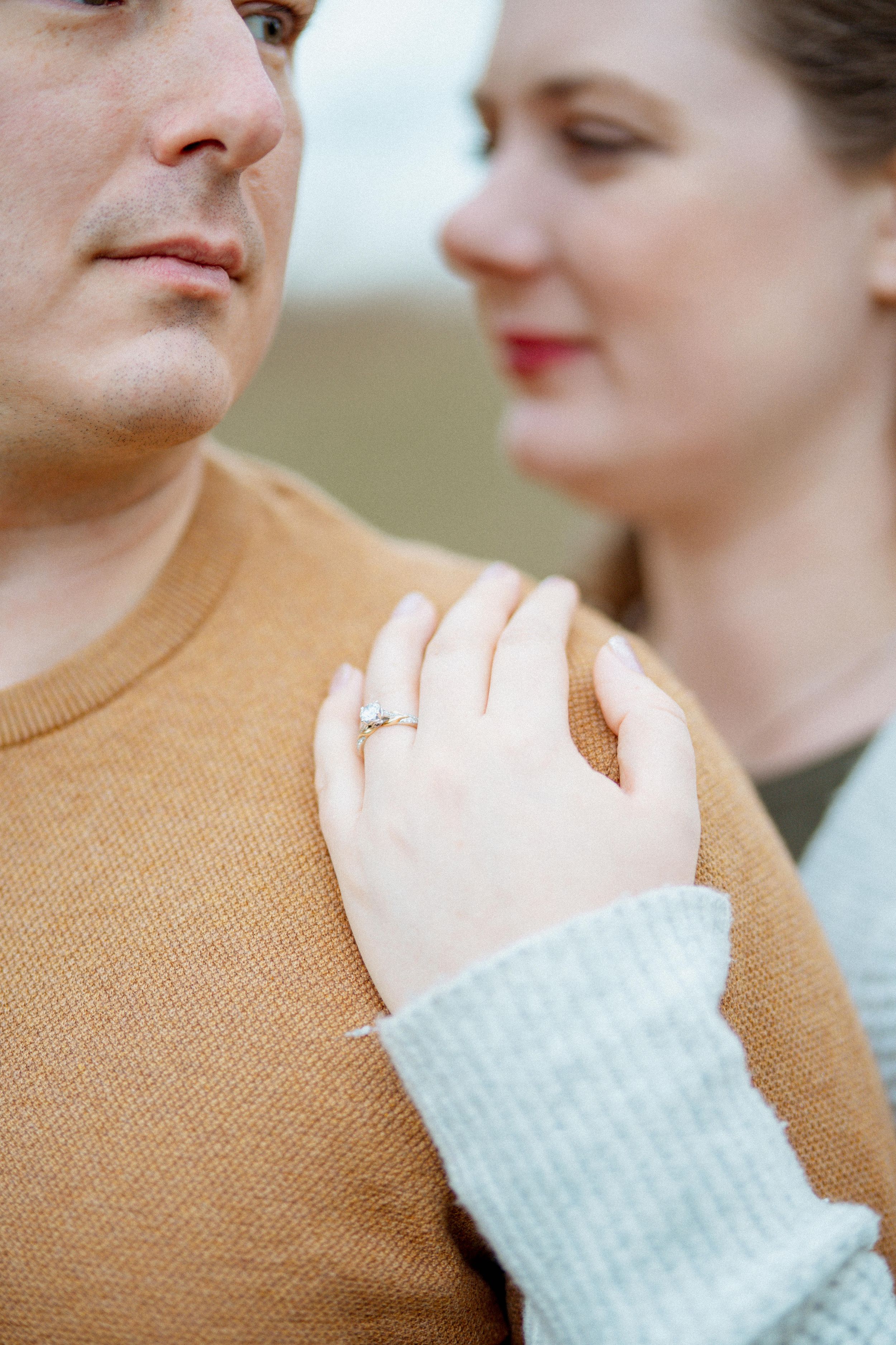 Close-up series showing a couple's tender moment with focus on an engagement ring and tan sweater.