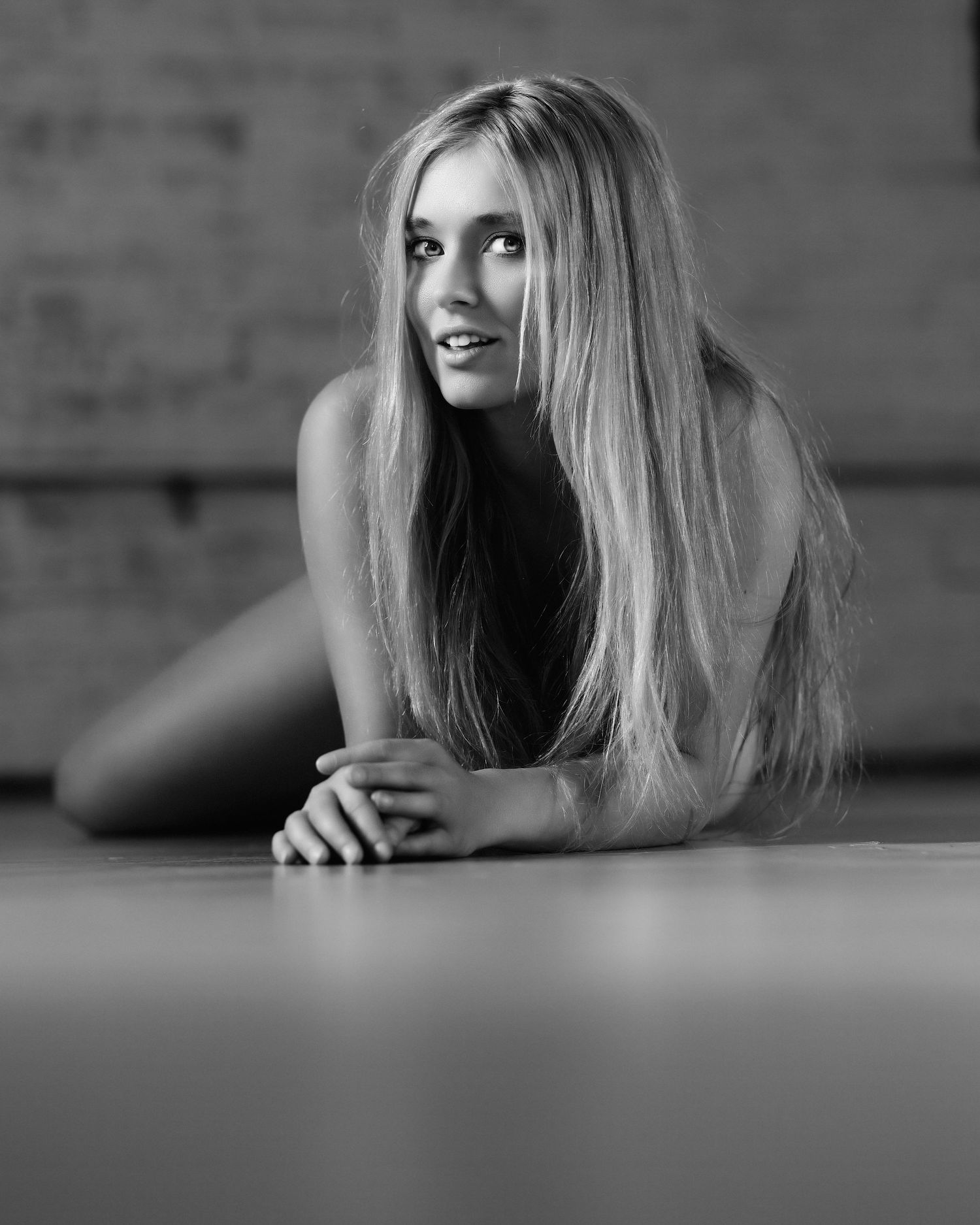 David G Holt Photography - Monochrome boudoir portrait with long blonde hair against textured wall.