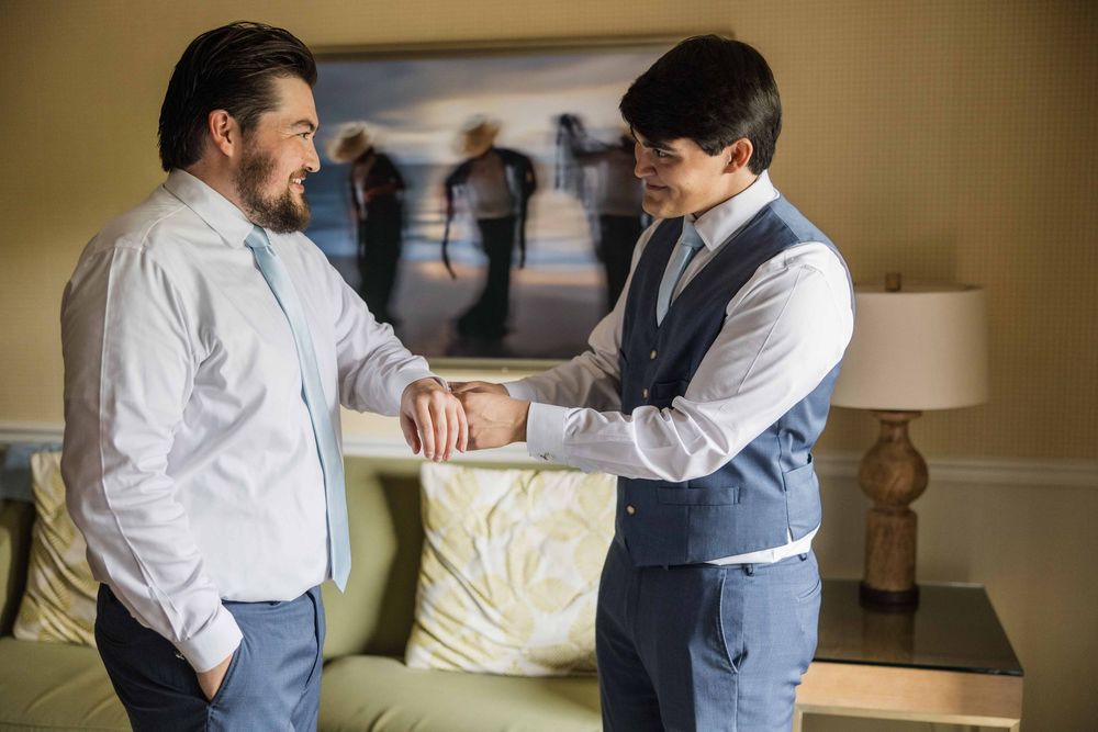 Two people in business attire discuss and review documents together in an office setting.