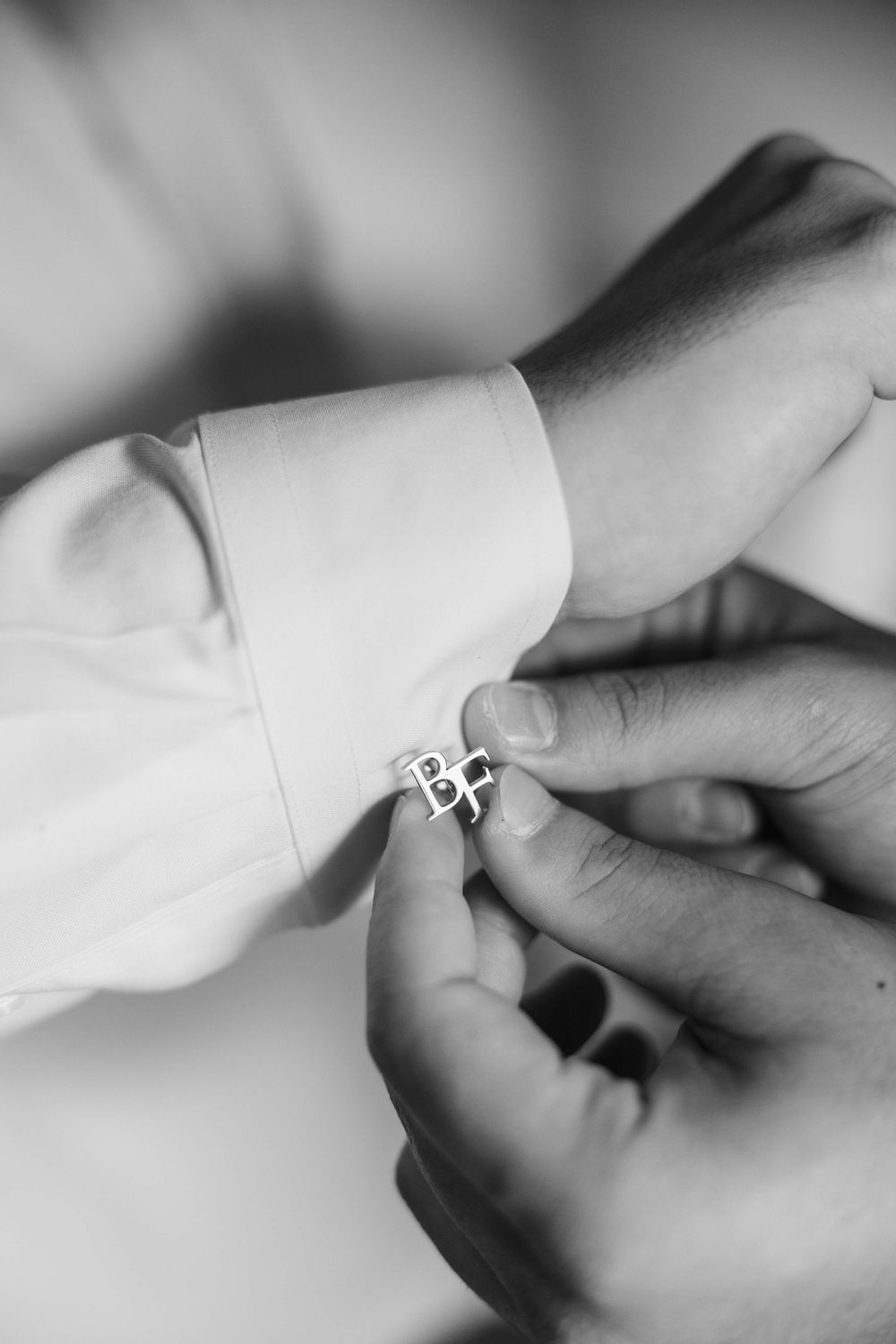 Close-up sequence showing a diamond engagement ring being placed on a finger in black and white photography.