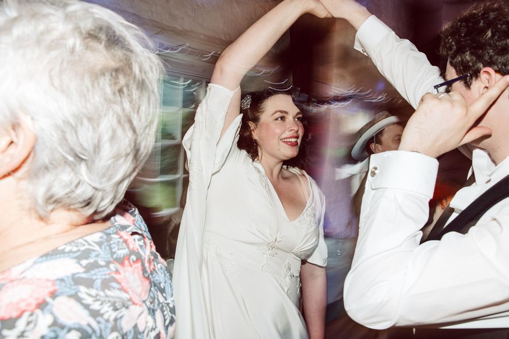 A collection of candid wedding reception photos showing dancing and celebration moments in black and white.