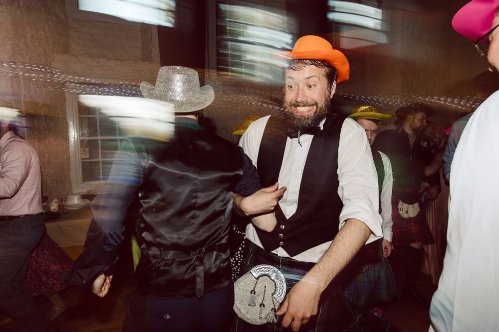 Passengers sit in a crowded subway car with people standing and holding onto handrails during a busy commute.