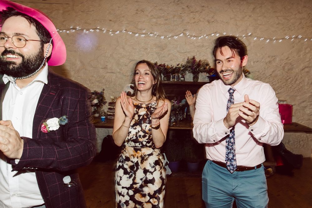 A series of candid dance floor moments at a party with string lights in the background.