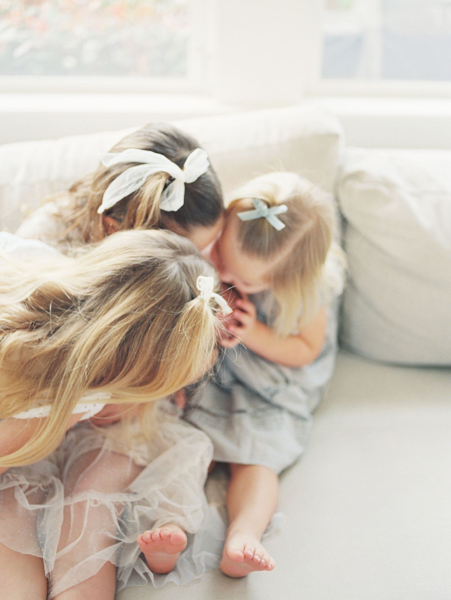 A series of dreamy, soft-focus photos showing a child in white clothing laying on light-colored bedding.
