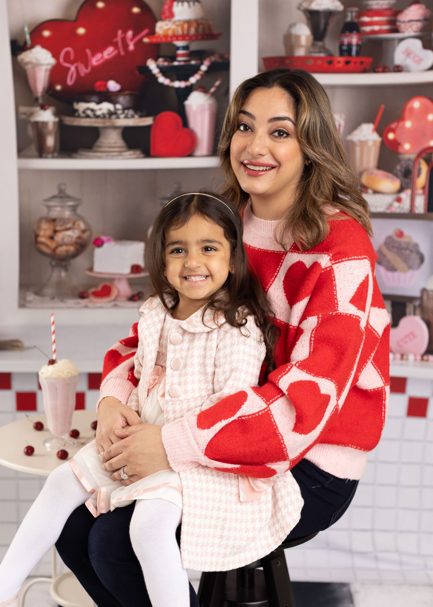 A heartwarming Valentine's Day themed photoshoot with red and pink decor in a cozy indoor setting.