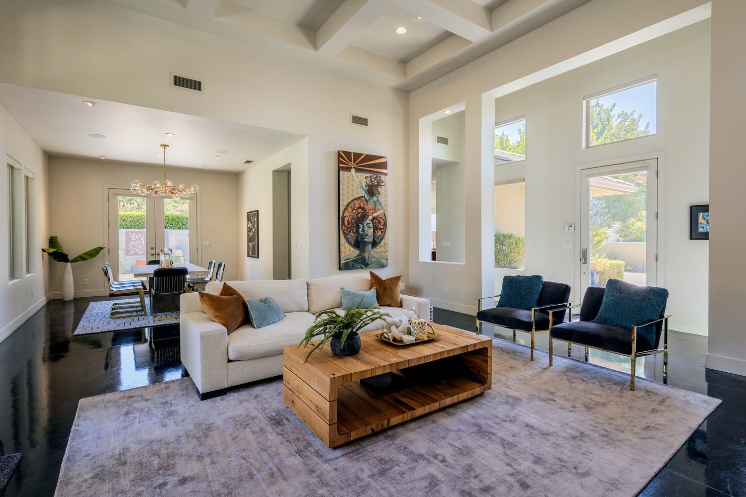 Modern open concept living room with floor to ceiling windows, wood beams, and mid-century modern furniture.
