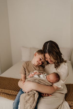 A heartwarming scene of comfort and rest as two embrace on a white couch with cozy cushions and woven textures.