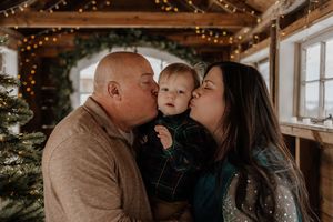 A loving family shares tender moments together in a cozy room decorated with twinkling string lights.
