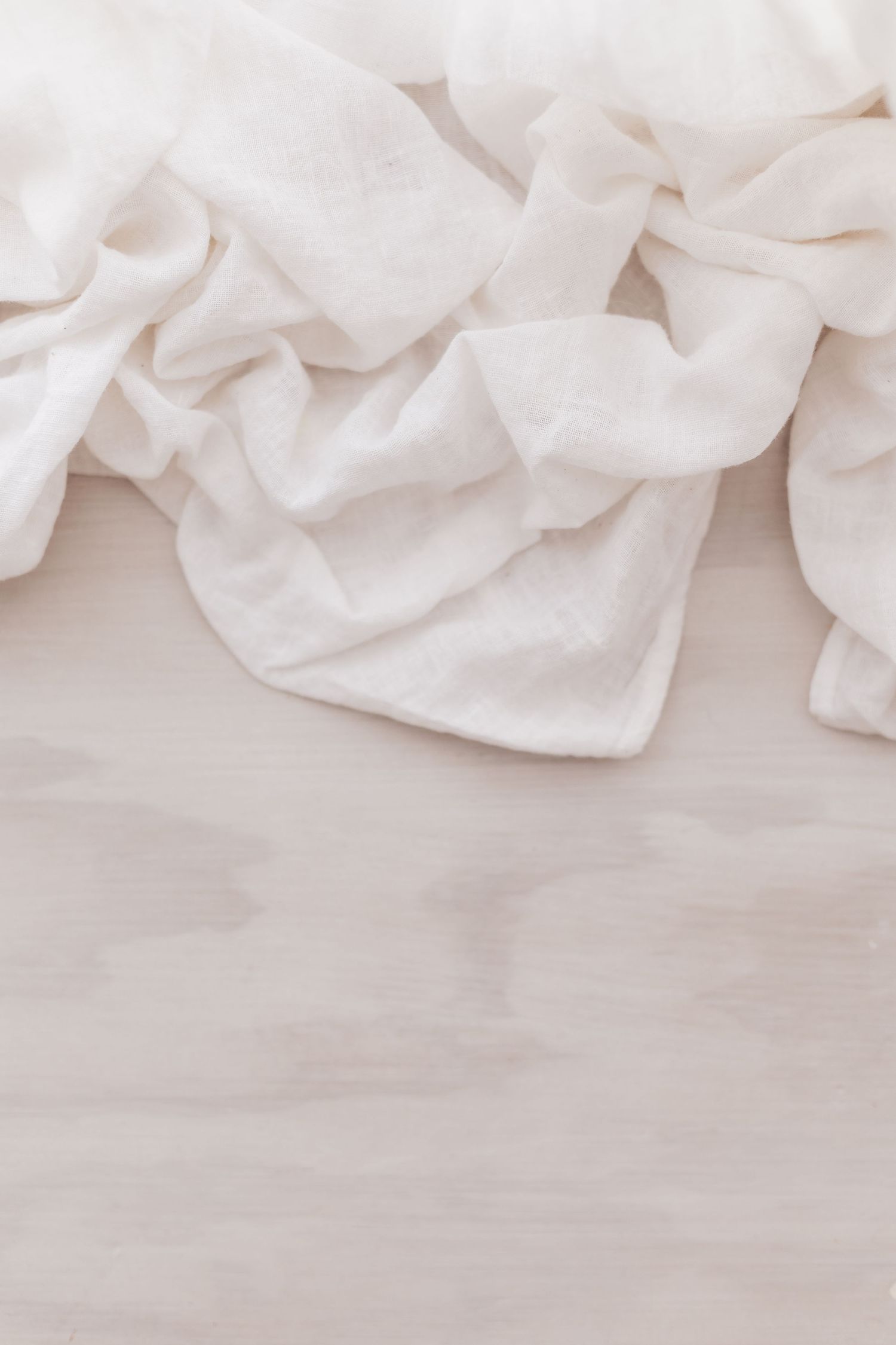 Soft white crumpled fabric texture creating an elegant background pattern.