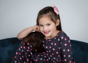 A person in a polka dot shirt poses playfully in a sequence of four connected photos.