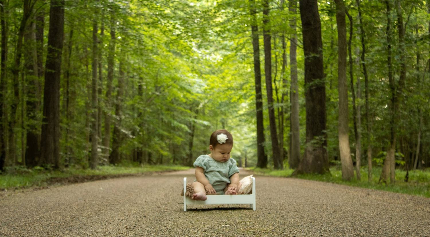 baby girl sage green dress sitting on a baby bench on a pebbled road in the French territory of yorktown va 
American Revolutionary war