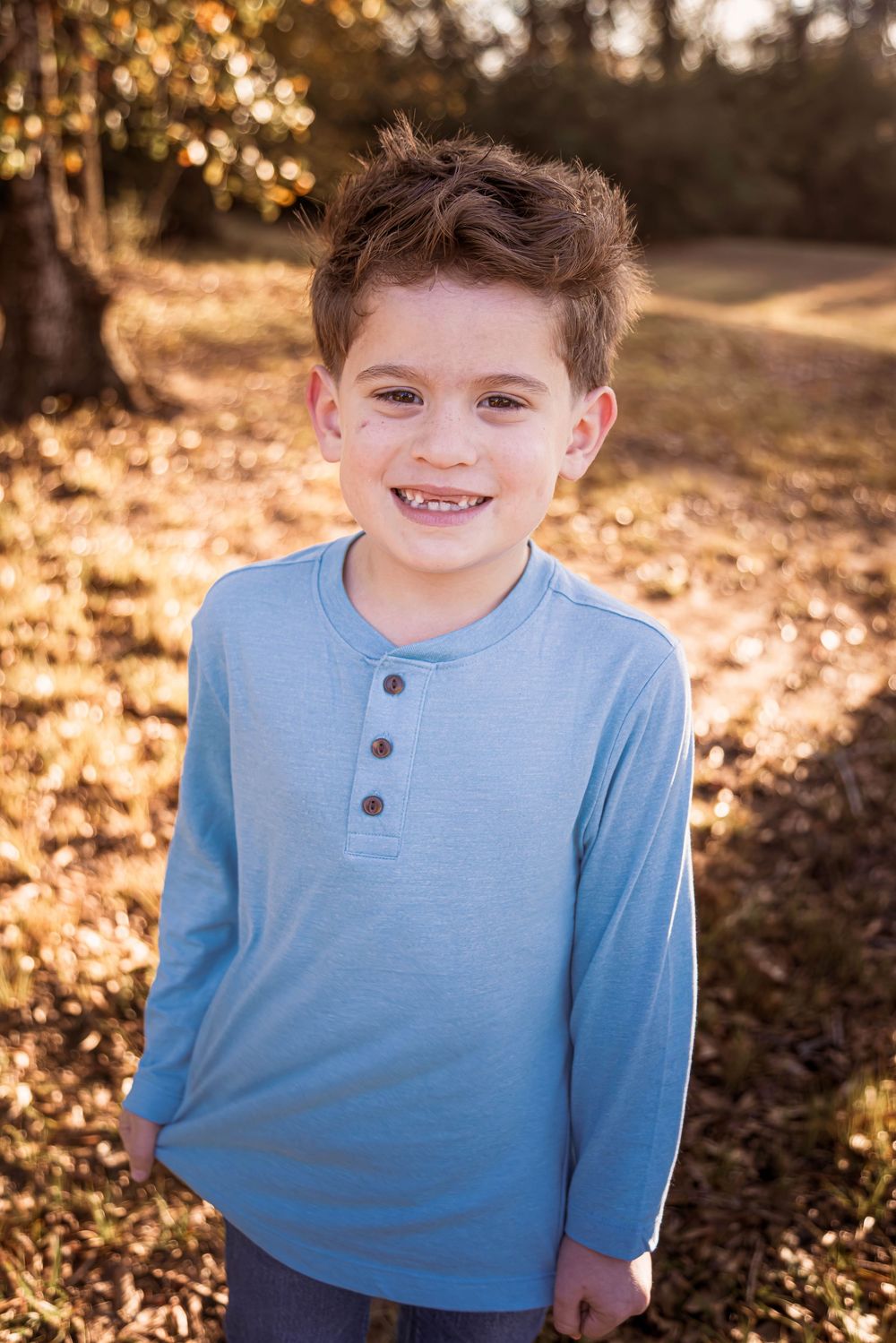 A series of candid outdoor portrait shots showing joyful expressions while wearing a light blue henley shirt.