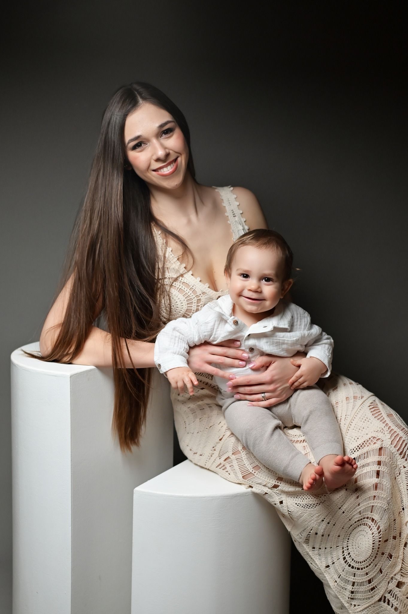 A series of tender portrait photos showing a parent and baby posing together against a neutral studio backdrop.