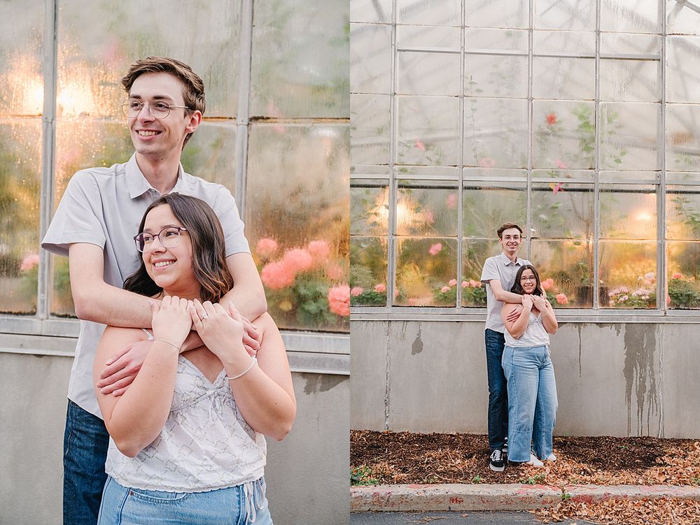 A couple shares romantic moments in a greenhouse during a sunset engagement photo session.