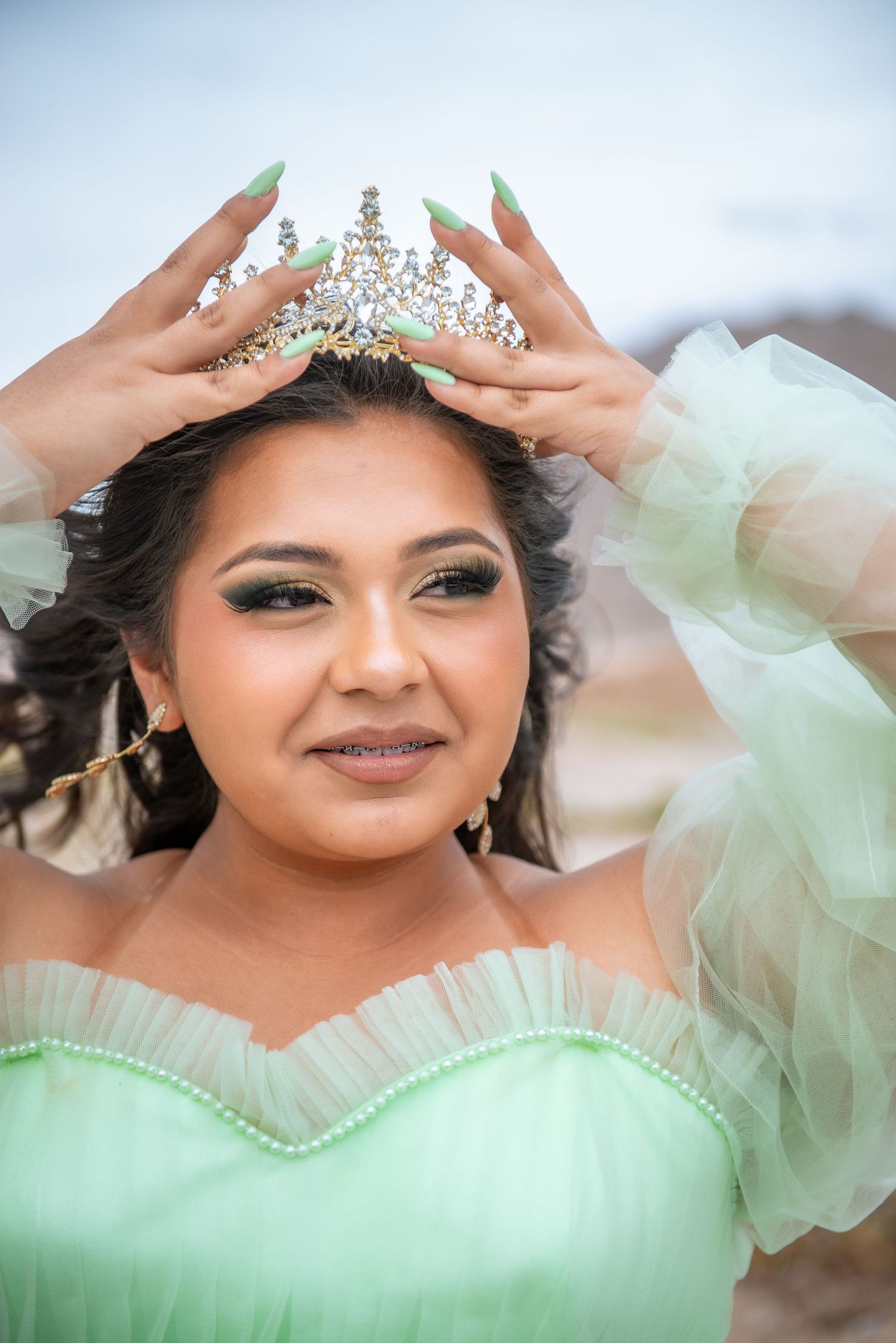 A sequence of photos showing a sparkling crown being placed on a mint green tulle dress.
