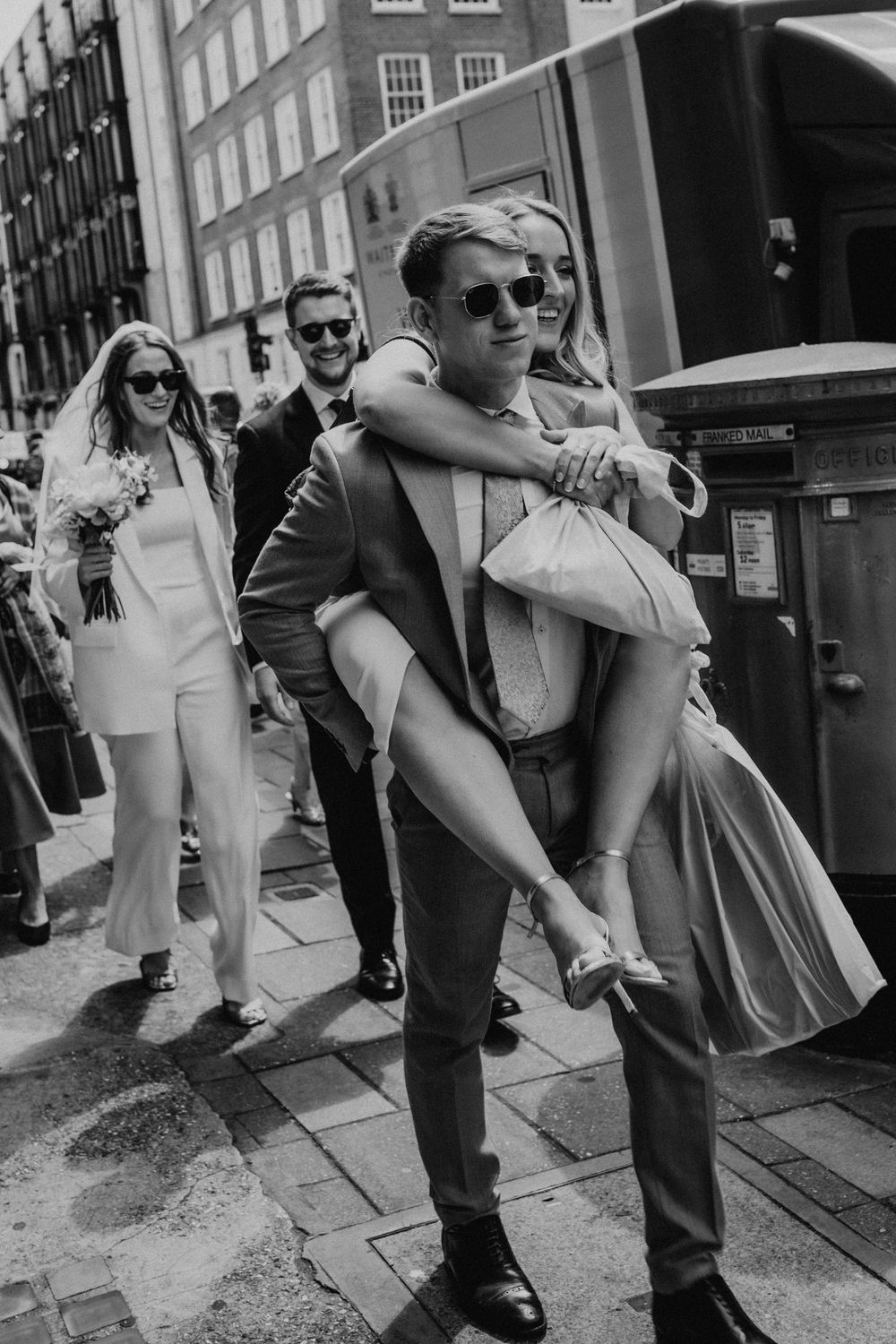 Black and white sequence of people dancing on a city street in vintage clothing.