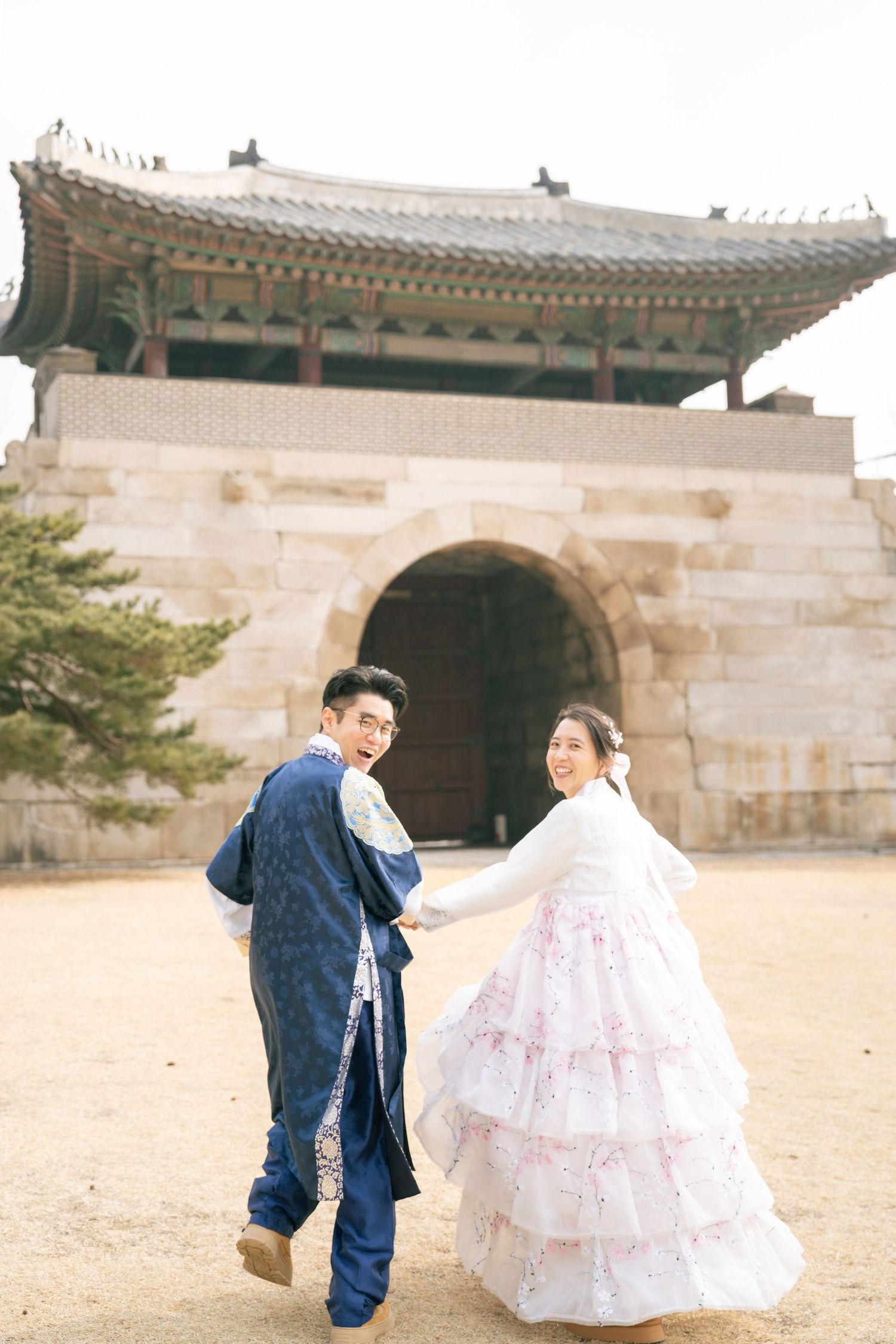 A couple in traditional Korean hanbok attire poses at a historic palace courtyard in a series of romantic shots.
