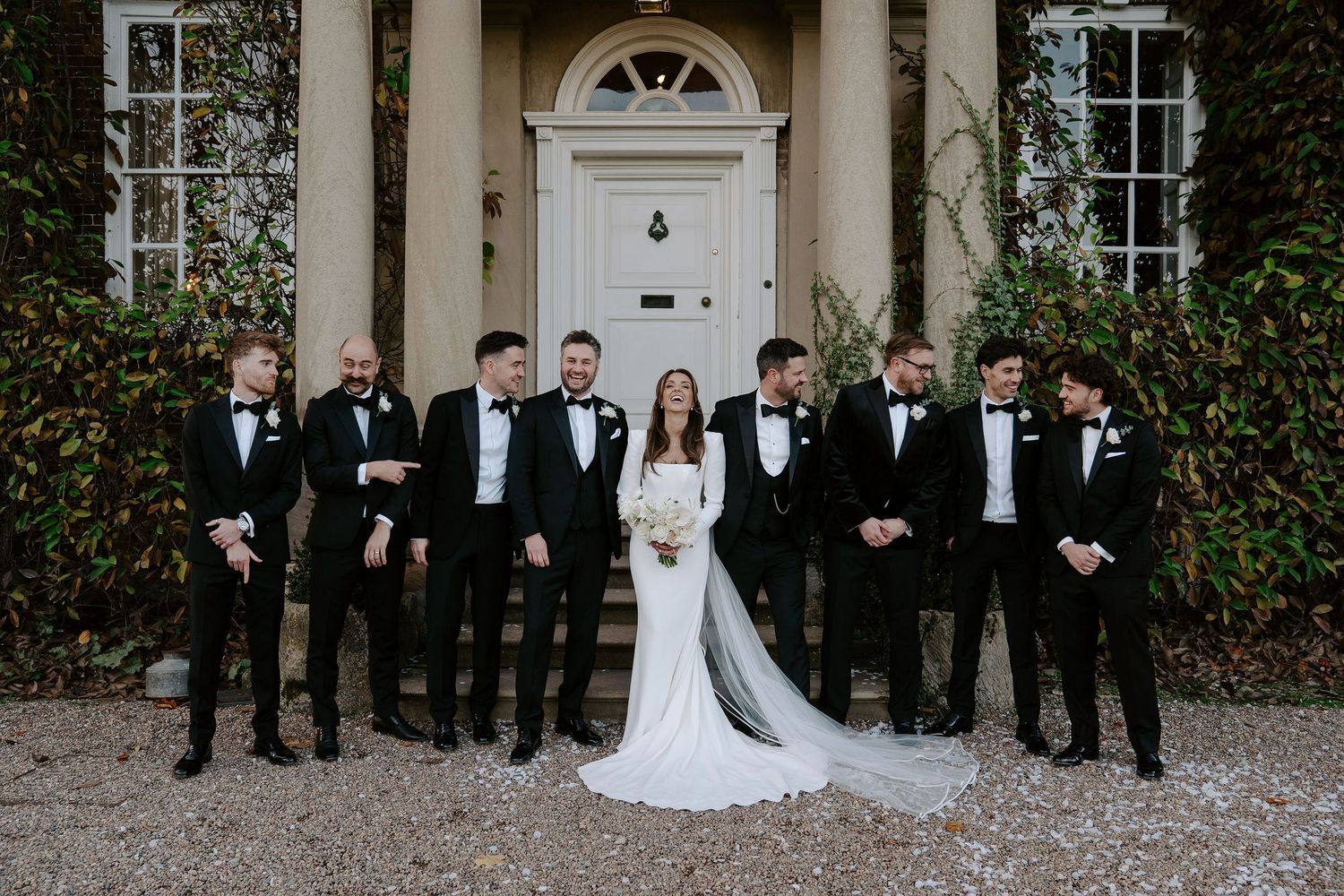 bride and groom and groomsmen talking and laughing outside Iscoyd park