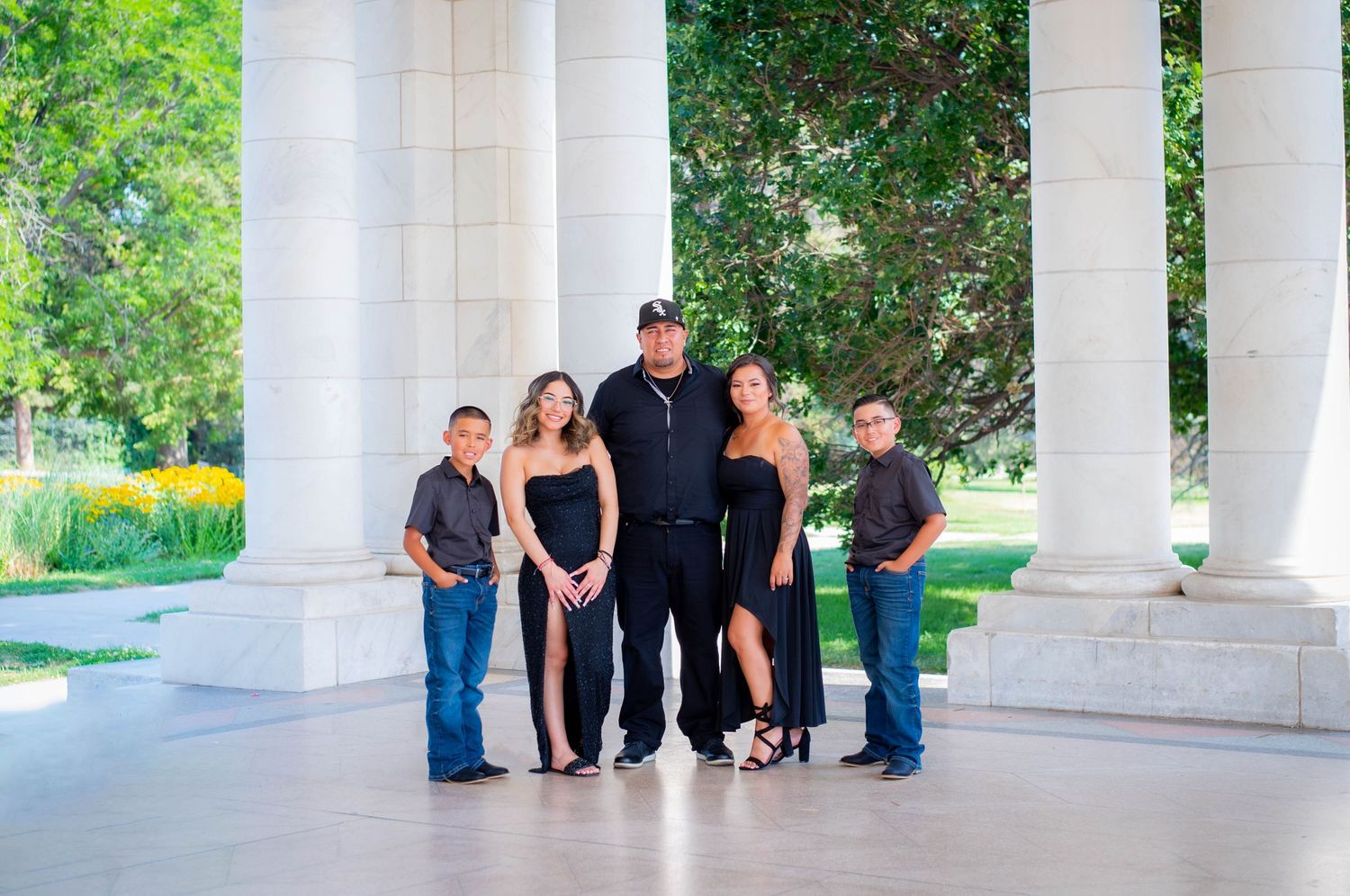 Group photoshoot under white columns in an outdoor garden setting.