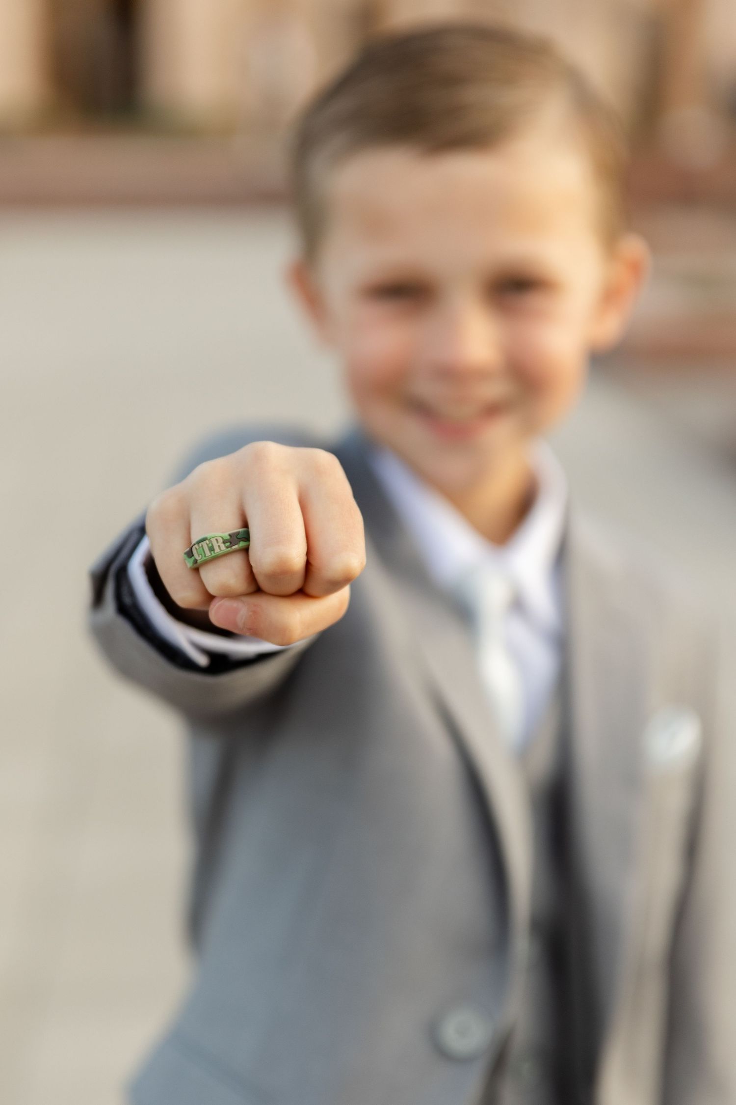 boy holding his hand out with CTR ring in focus he is blurry in the background